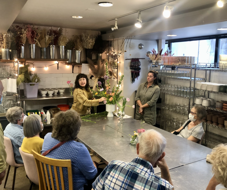 Older adults taking a flower arranging class. 