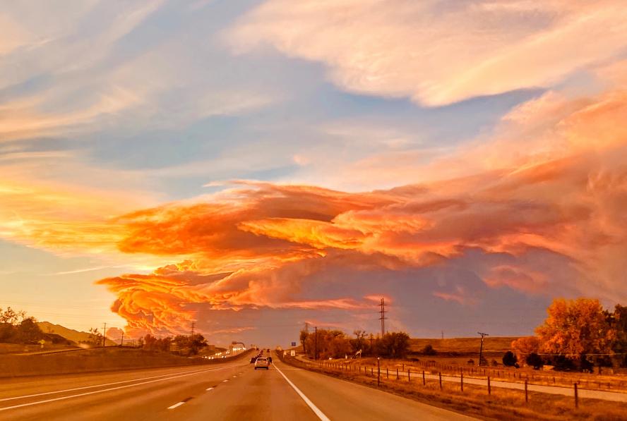 Photo of a road with pink smoke clouds stretching across the horizon.