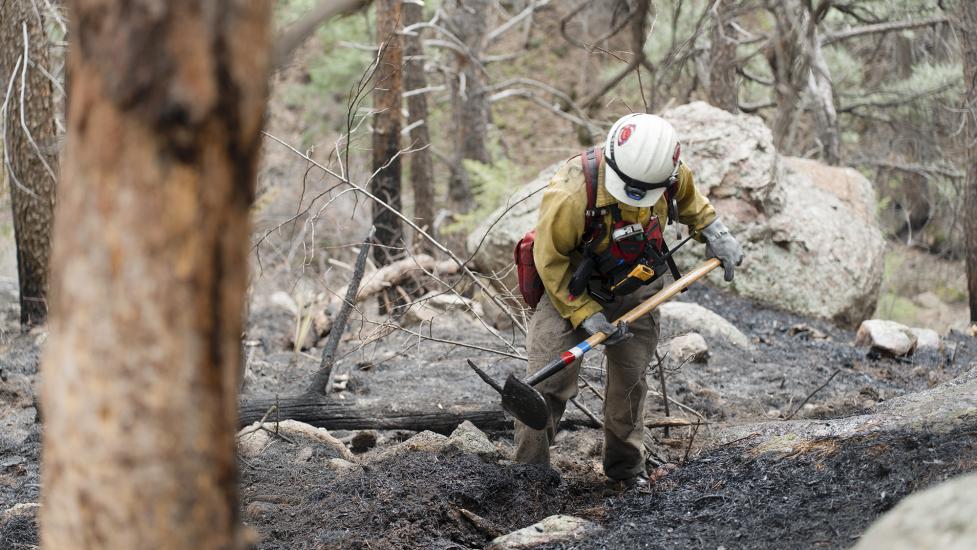 A Boulder wildland firefighter puts out hotspots during NCAR Fire
