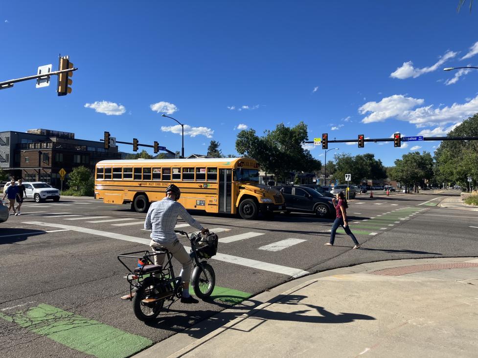 Pedestrians, a bicycle, a bus and other vehicles converge at the Folsom Street intersection.