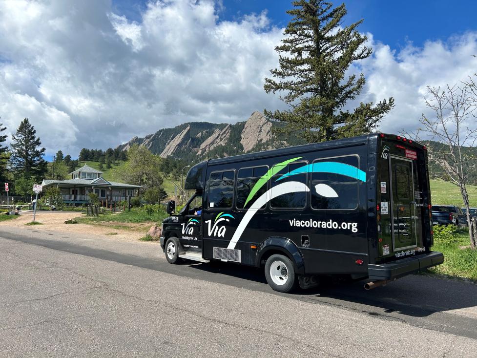 park-to-park shuttle, black with via logo, in front of flatirons