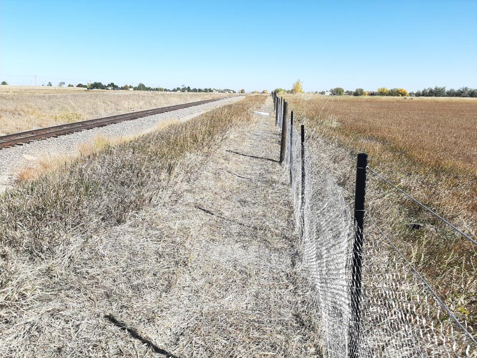 Barrier fence on the IBM property next to railroad tracks