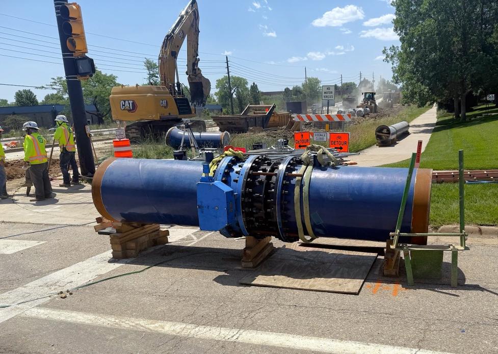 63rd Street waterline valve assembly; large blue pipe aboveground near construction