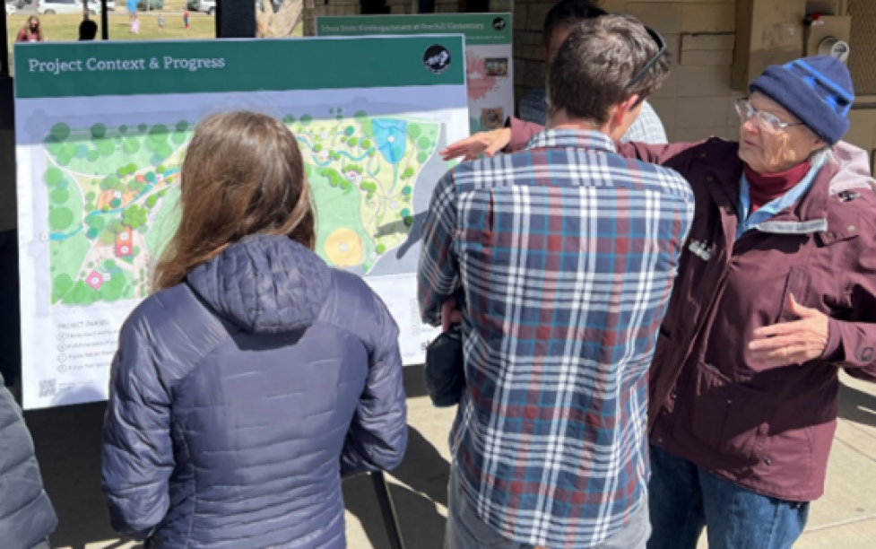community members looking at concept plan board at an outdoor meeting