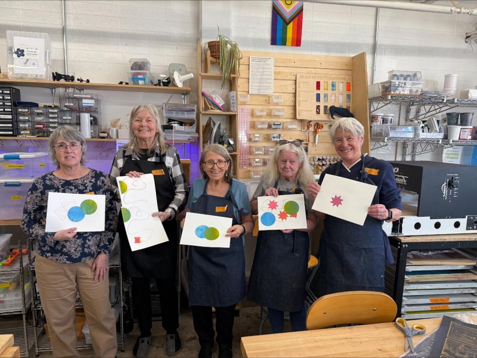 Older adult woman showcasing their artwork made at the Boulder Makerspace. 