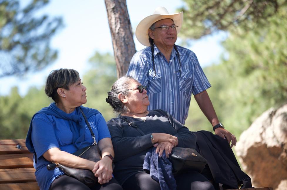 Candid portrait of Mr. Fred Mosqueda with his wife, Mrs. Mary Mosqueda, and daughter Clarinda Fletcher seated on a bench in a wooded area.