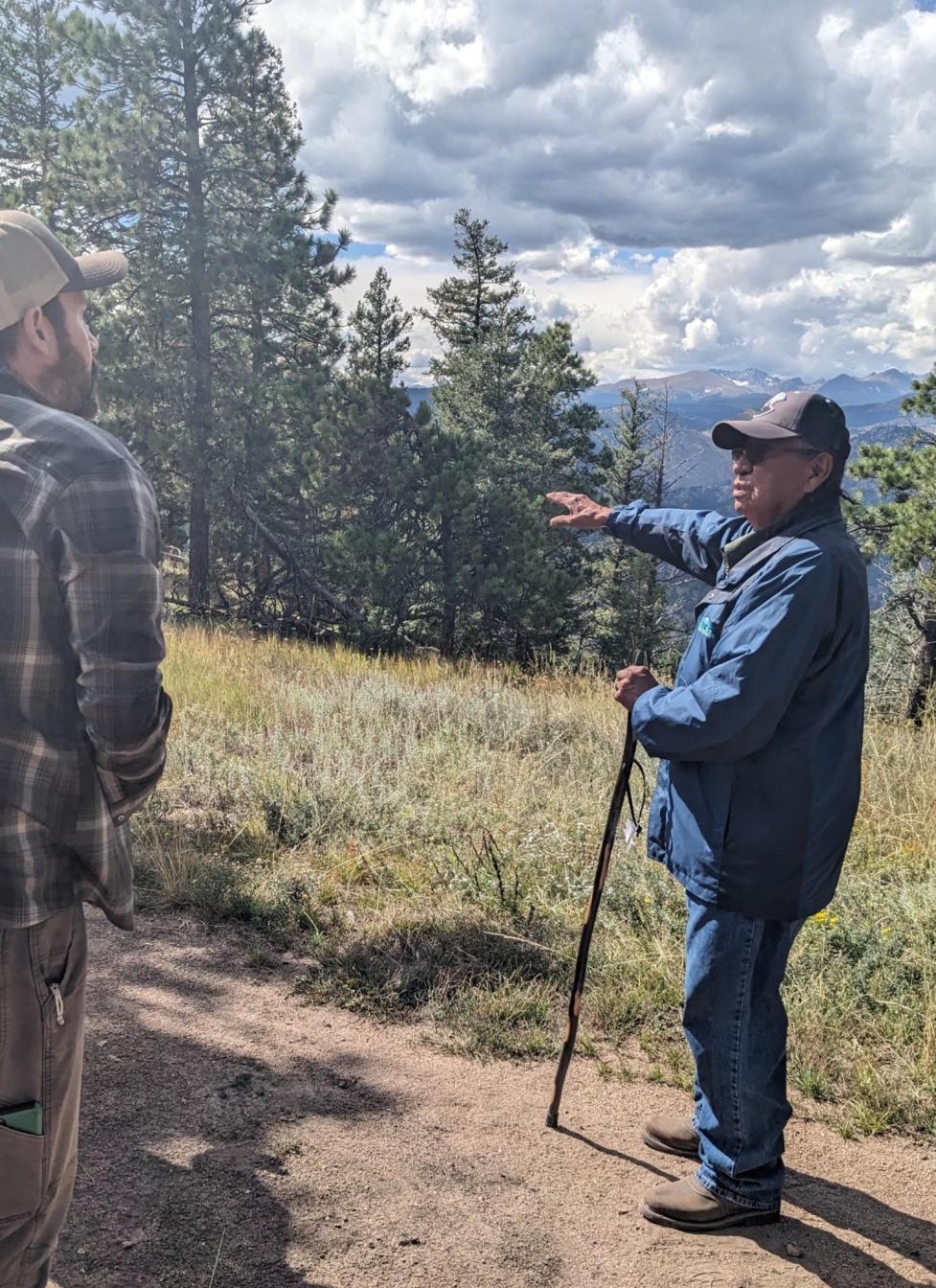 Mr. Terry Knight stands on a wooded trail in profile, speaking to someone off‑camera.