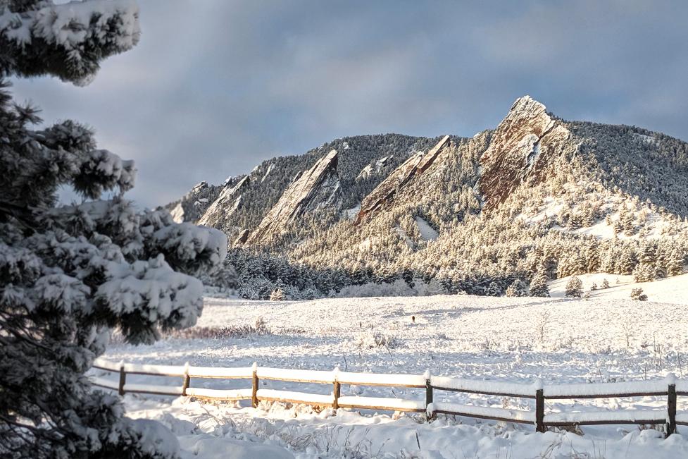 Snow covered mountains behind a white snowy field.