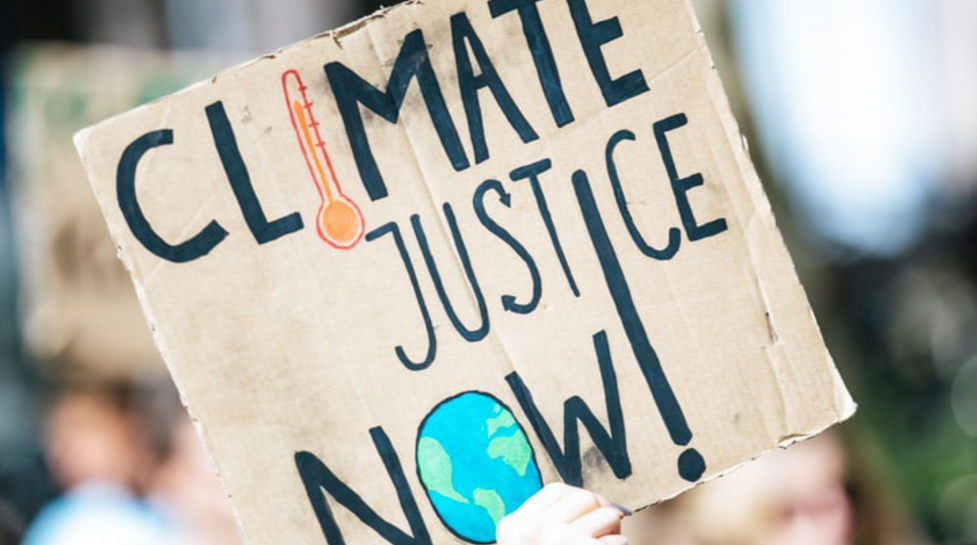 A protest sign with the message: Climate justice NOW!