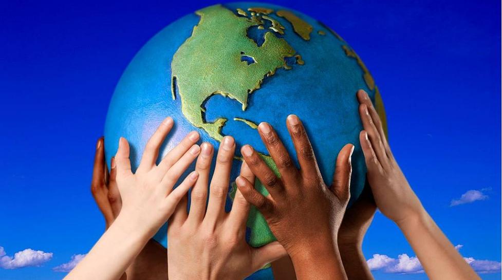 Group of hands holding up a globe