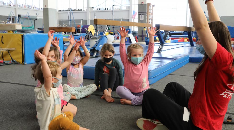 Kids with hands up in gymnastics