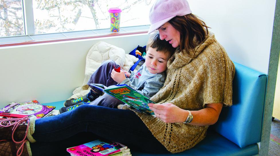 Child reading with mom in children's library 