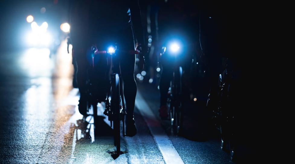 Darkness with two bikes barely visible with their headlights on