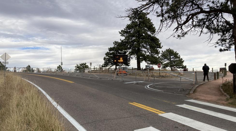 Two way road with a big pull off being blocked by a mental gate.