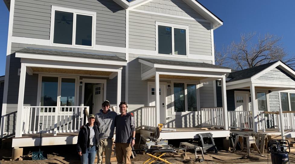Volunteers posing in front of the first three foundation-built Ponderosa homes in May 2024. 
