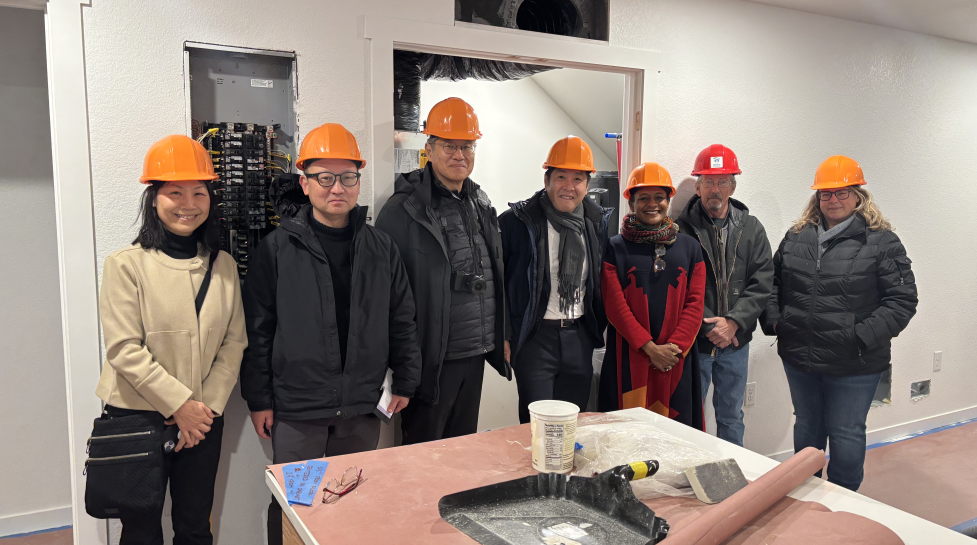 A delegation from the Japan Off-site Construction Association, a liason from Boulder-Yamagata City Friendship Committee, Councilmember Taishya Adams and Habitat staff pose for a picture in the kitchen of a BoulderMOD modular home. 