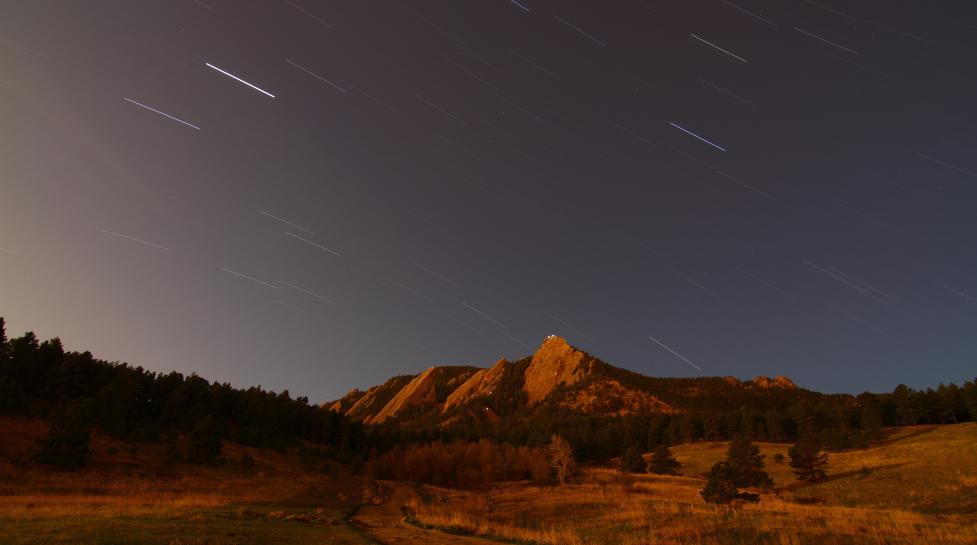 Boulder Flatirons under a starry night sky
