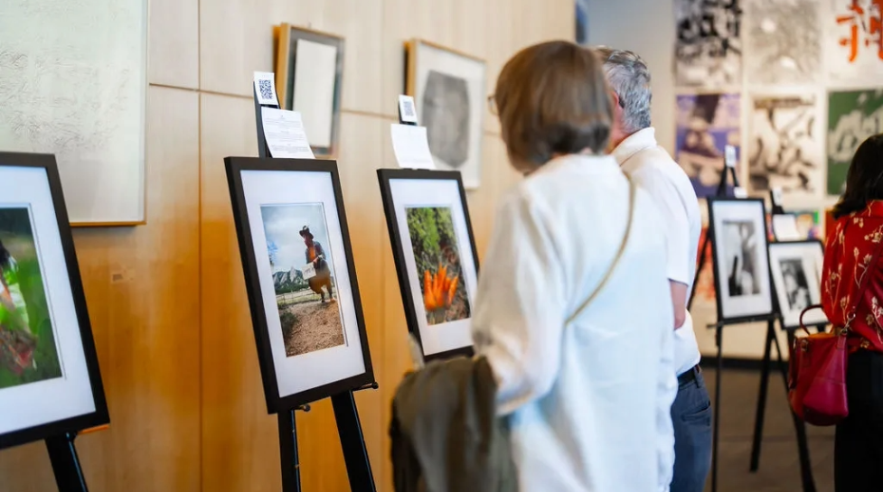 Woman and man viewing a gallery of images taken by Elevate Boulder participants.