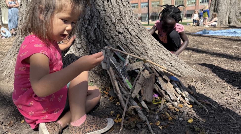 children building and playing with sticks in civic area