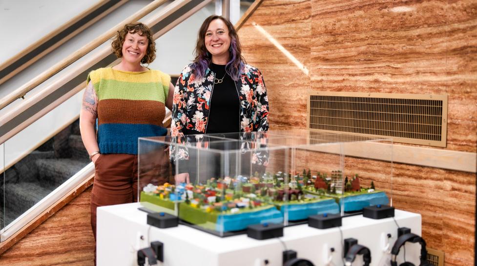 Artists standing behind their project in the Penfield Tate Municipal Building lobby