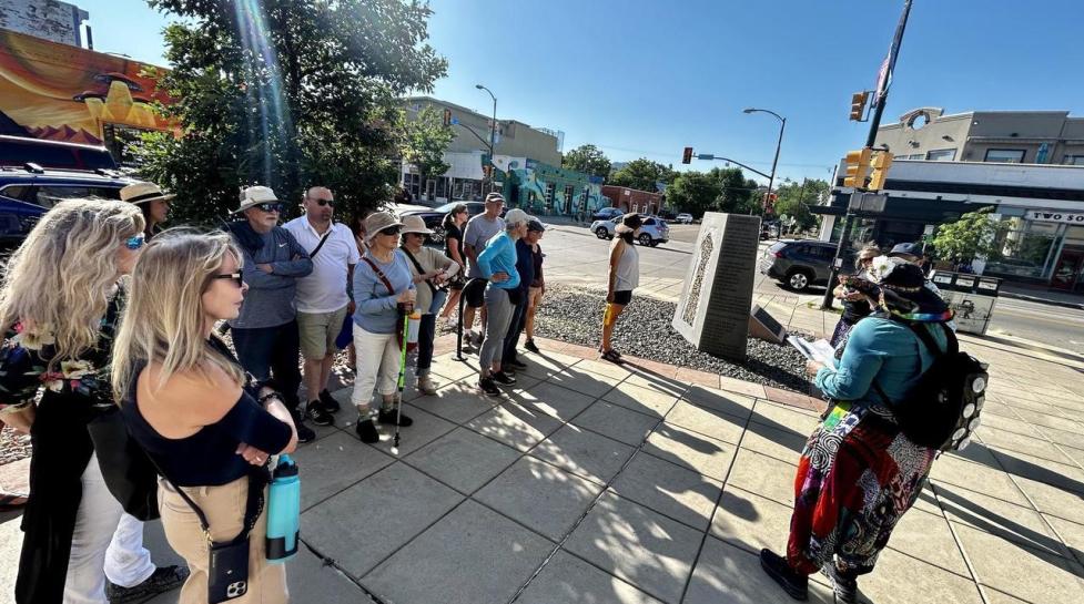 Participants of a public art tour listening to the guide