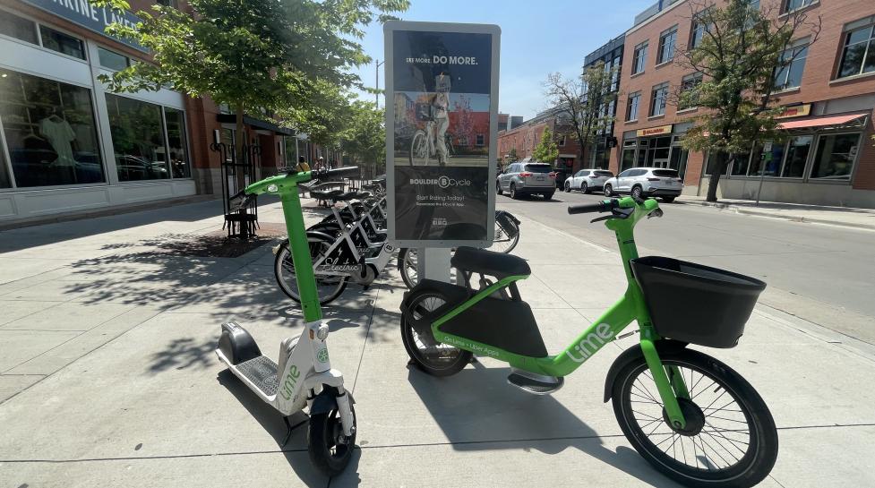 scooter and glider in front of a parking station in downtown boulder