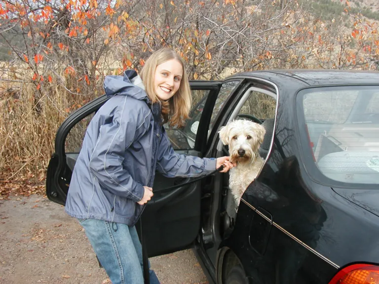 Woman getting dog out at trailhead