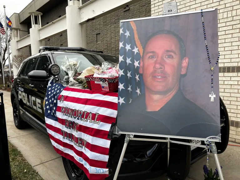Officer Eric Talley photo in front of police car memorial