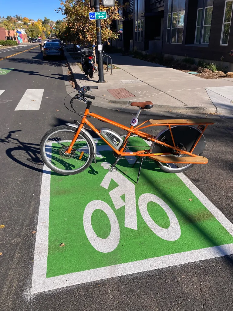 A bright orange bike on a two-stage left-turn queue box