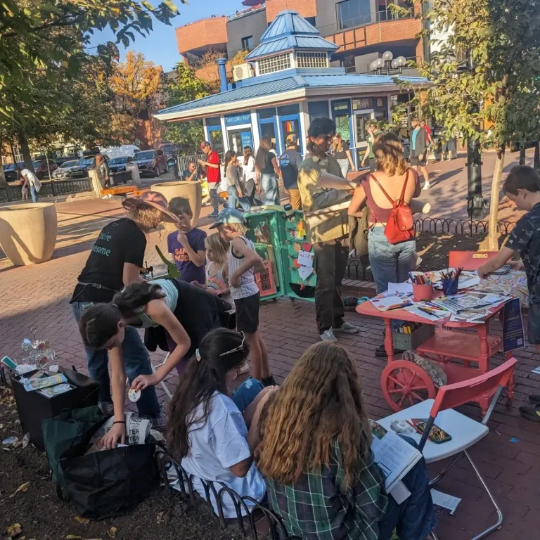 Children and adults interacting with an art station.
