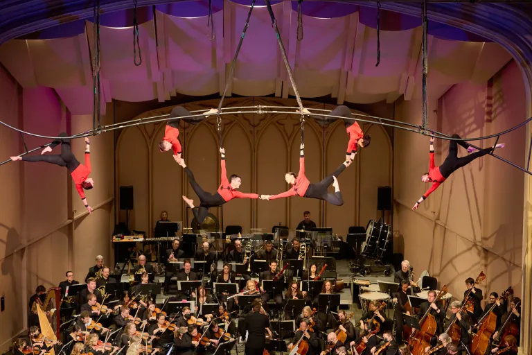 Aerial performers above an orchestra.