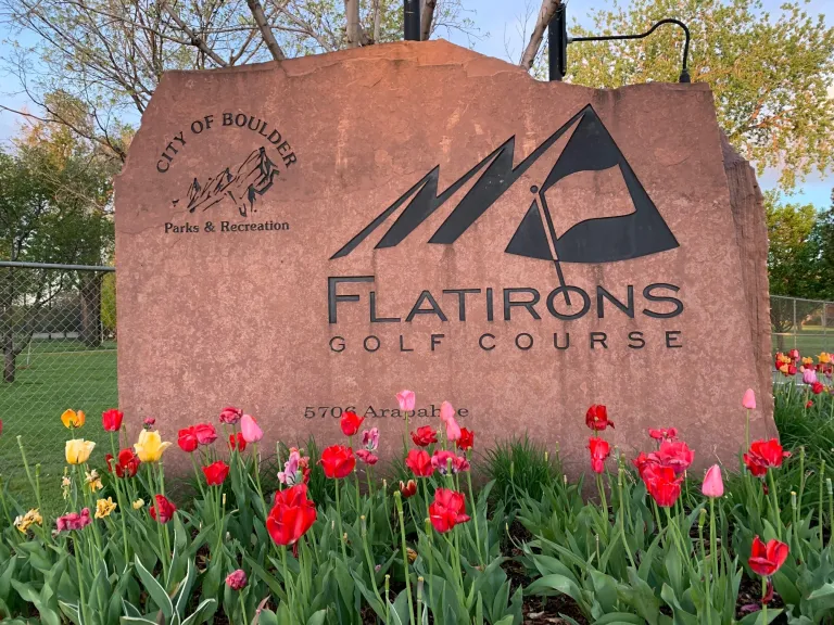 Flatirons Golf Course entry sign with tulips