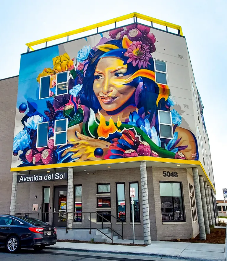 Colorful mural on side of a building featuring a woman's face and flowers