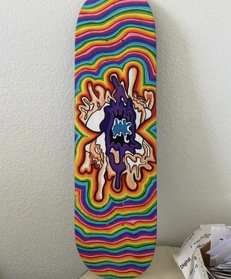 A vibrant form in the middle of a rainbow-colored skateboard 