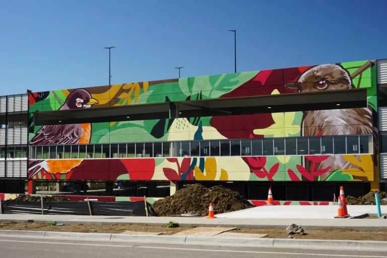 Mural of birds on the side of a parking garage with the image continuing on multiple floors 