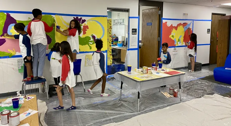 Abstract shapes with students painting the mural