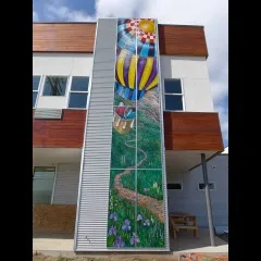 Mural of a grasslands with a hot air ballon floating above
