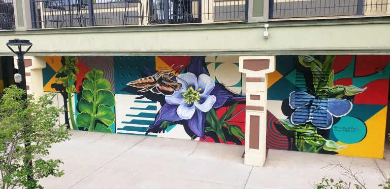 Mural with flowers and a moth in front of geometric patterns