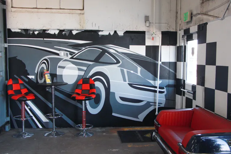 Multi-wall mural of a car racing along a road