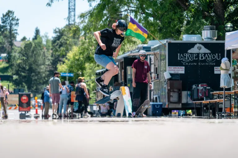 Skateboarder on 13th Street with food trucks behind them