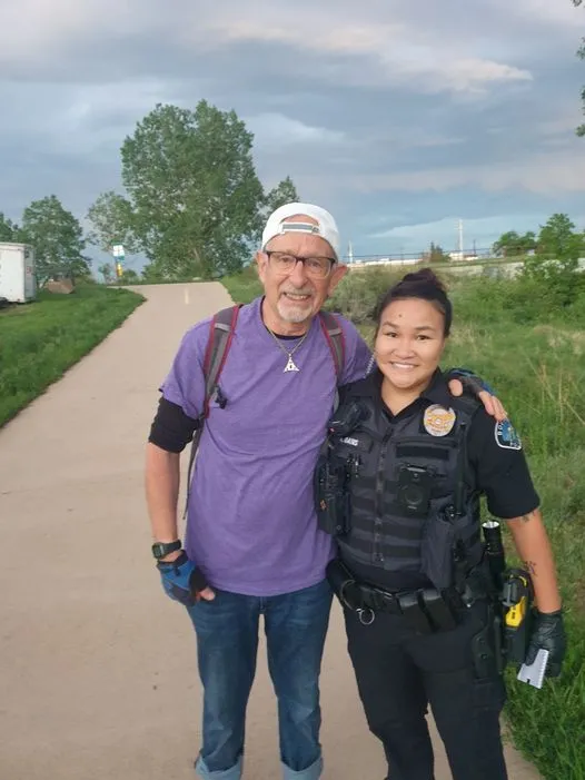 A Boulder Police officer posing for a photo with a community member on a multi-use path