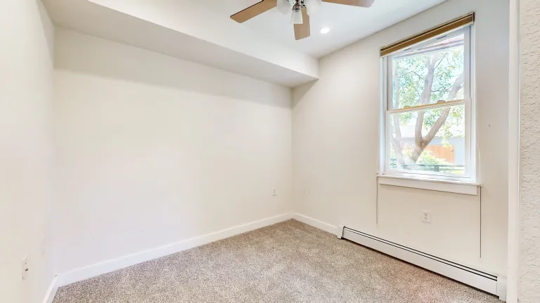 Other bedroom view with fan and window