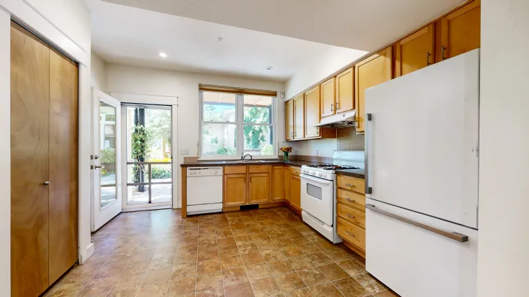 Full kitchen view and looking out to the window and glass door
