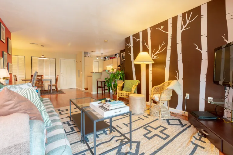 Other side livingroom view painted tree wall and large floor carpet