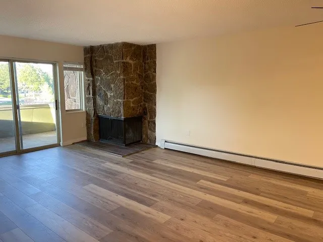 3150 Iris Ave #F211 - living room with new flooring and fireplace looking onto porch