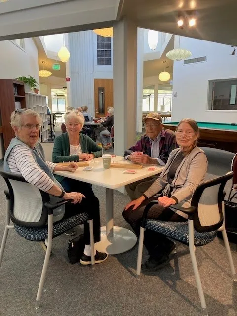 Four women sit around a table to play Mah Jongg at the West Age Well Center