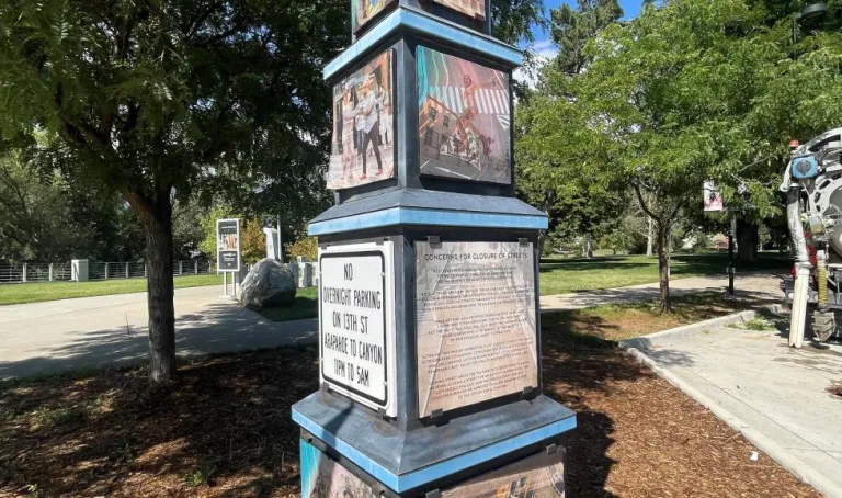 Pole covered in artistic wheatpaste images of people