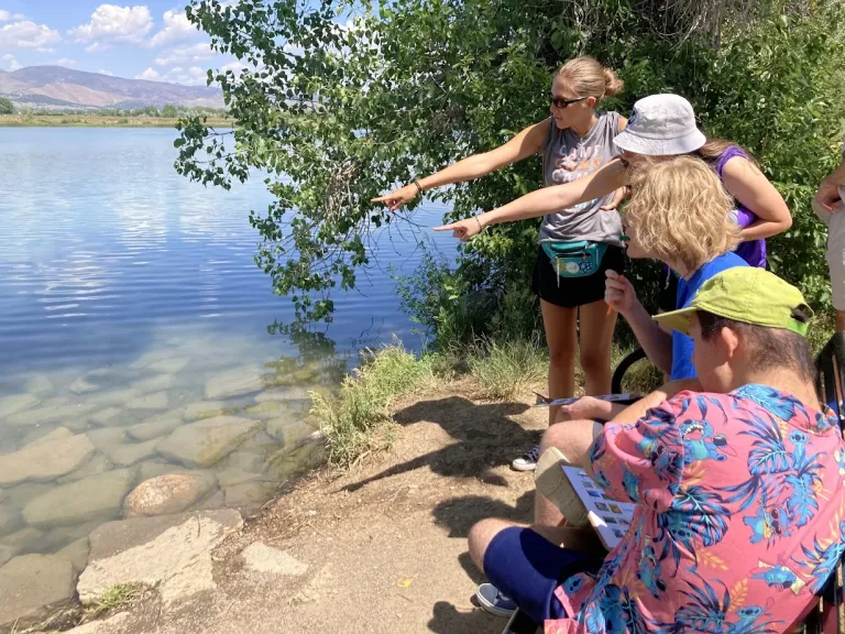 Amico campers on a field trip, looking in a lake