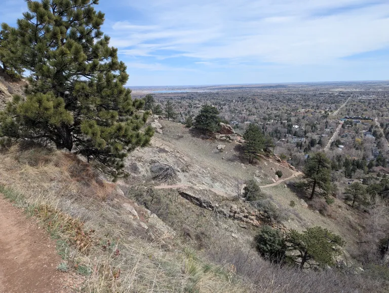 The steep, narrow Goat Trail winds along a canyon-side with a neighborhood below.