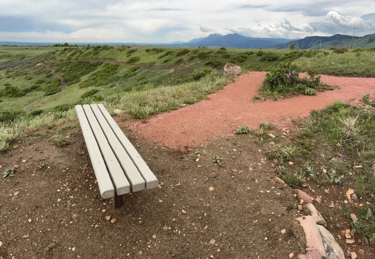 A bench along the Shale Trail with a few of the foothills
